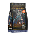 The front of a 12 ounce bag of Bones Coffee Company Army of Dark Chocolate decaf coffee. Its flavor is dark chocolate, and it has a skeleton wielding a chainsaw standing on dark chocolate with a woman clinging to its leg on the art.