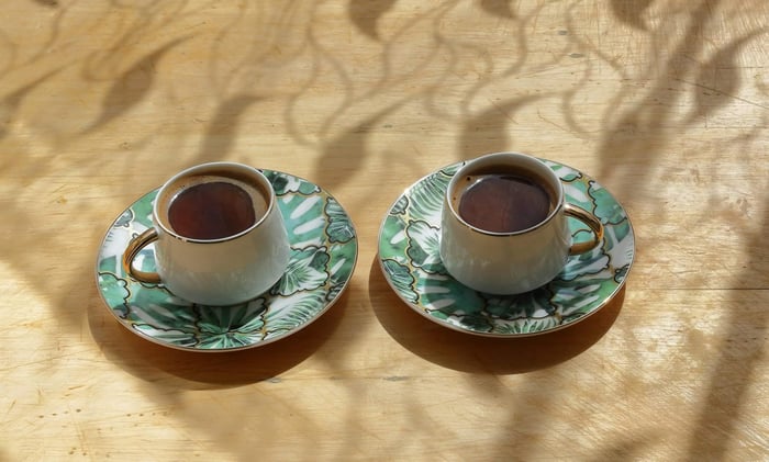 Elegant coffee cups with green floral design