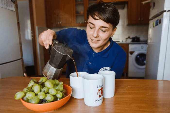 person pouring coffee in white cups